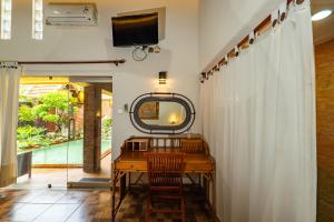 a dressing room with a desk and a mirror at Sajjana House Bali By Magno in Nusa Dua