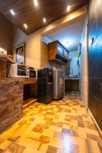 a large kitchen with a wooden floor and appliances at Sajjana House Bali By Magno in Nusa Dua