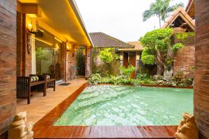 a swimming pool in the backyard of a house at Sajjana House Bali By Magno in Nusa Dua