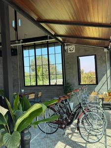 a group of bikes parked in a room with windows at Namkhan Rivora Resort in Luang Prabang