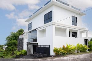 a white house with large windows at Villa Nuansa in Mantaak