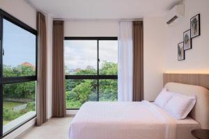 a bedroom with a bed and a large window at Villa Nuansa in Mantaak +44 photos