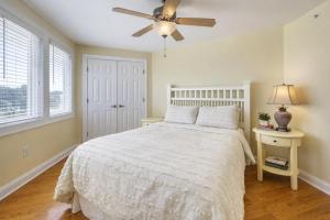 a bedroom with a white bed and a ceiling fan at Captains Watch in Tybee Island +13 photos
