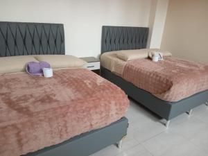 two beds sitting next to each other in a bedroom at Residencial La Castilla in Quillacollo +7 photos