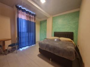 a bedroom with a bed and a table and blue curtains at Residencial La Castilla in Quillacollo