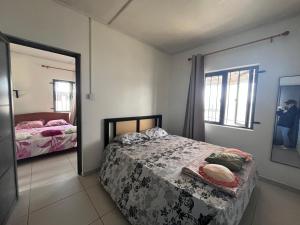 a bedroom with a bed and a mirror at Ashan Laksh Bungalow in Grande Rivière Sud Est