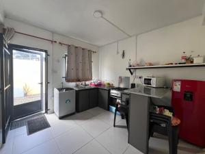 a kitchen with a red refrigerator and a counter top at Ashan Laksh Bungalow in Grande Rivière Sud Est