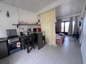 a kitchen with a desk and a table in a room at Ashan Laksh Bungalow in Grande Rivière Sud Est