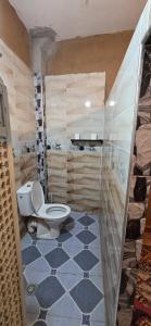 a bathroom with a toilet and a tile floor at Desert feet in Mhamid
