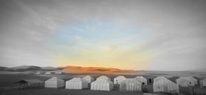 a group of white buildings in the desert at Desert feet in Mhamid