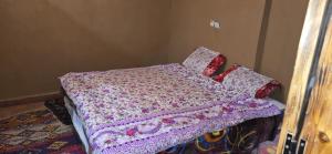 a bed with a pink blanket and pillows on it at Desert feet in Mhamid +7 photos
