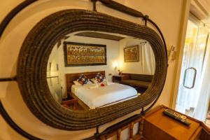 a bedroom with a bed and a large mirror at Sajjana House Nusadua By Magno in Nusa Dua +5 photos