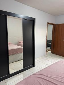 a bedroom with a large mirror and a bed at Apartamento Sabrina in Curitiba
