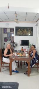 two women sitting at a table in a room at Villa 22 Negombo in Negombo