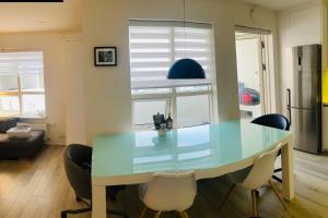 a dining table and chairs in a living room at Friggjarbrunnur shared home in Reykjavík