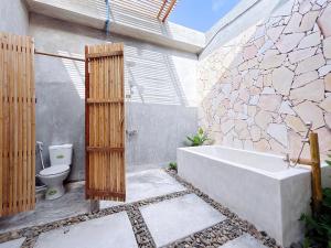 a bathroom with a bath tub and a toilet at Emerald Beach Homestay in Bình Sum