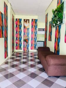 a living room with a couch and a checkered floor at Landayan Traveller Inn in Baco Medio Island