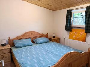 a bedroom with a bed with blue sheets and a window at Nachhaltiges Ferienhaus in Steinheim in Steinheim