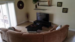 uma sala de estar com um sofá castanho e uma televisão em Sunny Paradise em Cape Coral