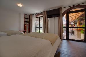 a bedroom with a bed and a large window at Hotel Punto 79 in San Miguel de Allende