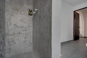 a bathroom with a stone wall and a shower at Hotel Punto 79 in San Miguel de Allende