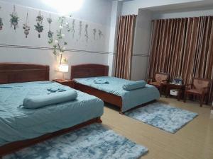 a bedroom with two beds and a table and chairs at LUNA House in Hue