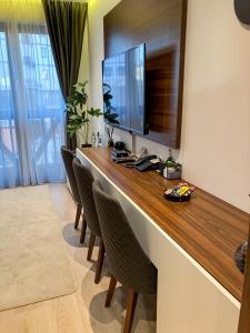 a room with a long table with chairs and a television at Zoned MASLAČAK lux - SPA & Wellness Kopaonik in Kopaonik