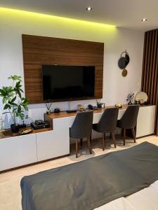 a living room with a tv and a table and chairs at Zoned MASLAČAK lux - SPA & Wellness Kopaonik in Kopaonik