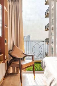 a bedroom with a bed and a chair on a balcony at Sunhaven Studio I Work & Leisure Stays I Near Expo Mart in Greater Noida