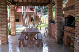 einen Holztisch und Stühle auf einer Terrasse im Freien in der Unterkunft Pousada Farol da Barra in Florianópolis