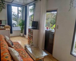 a living room with a couch and a television at Art Bungalow Amami in Amami +4 photos