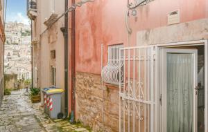an alley in an old town with a white gate at Casa Giulia 8 in Ragusa