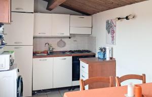 a kitchen with white cabinets and a stove top oven at Casa Giulia 8 in Ragusa