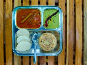 a lunch box with rice and different types of food at Saguna Baug Agro Tourism in Neral
