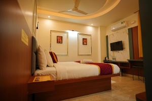 a bedroom with a bed and a desk and a television at SN Comforts in Bangalore