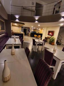 a living room with tables and chairs and a couch at Hotel MH Pereira in Pereira