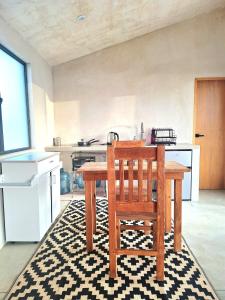 a kitchen with a wooden table and a chair at Casita Atardecer in Todos Santos +8 photos