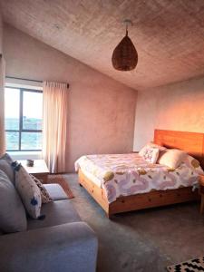 a bedroom with a bed and a couch at Casita Atardecer in Todos Santos