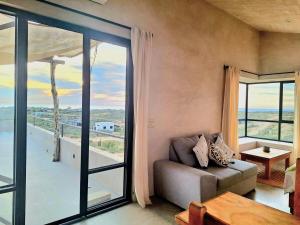 a living room with a couch and a large window at Casita Atardecer in Todos Santos