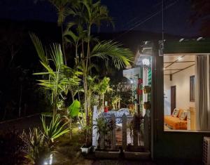 a garden at night with palm trees and a house at Art Bungalow Amami in Amami
