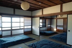 a room with two beds and a mirror at 古民家宿torch in Fujikawaguchiko
