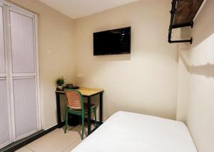 a bedroom with a desk and a bed and a television at Swing & Pillows - Sentul Jalan Ipoh Kuala Lumpur in Kuala Lumpur