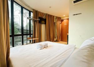 a bedroom with a large white bed with towels on it at Swing & Pillows - Sentul Jalan Ipoh Kuala Lumpur in Kuala Lumpur +17 photos