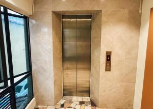 a metal elevator in a building with a window at Swing & Pillows - Sentul Jalan Ipoh Kuala Lumpur in Kuala Lumpur