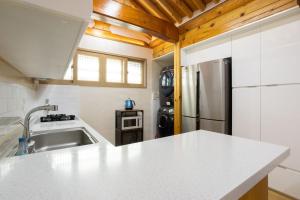 a kitchen with a white counter top and a refrigerator at HakMinJae Hanok Stay in Seoul