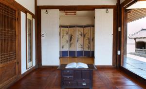 a room with a desk with a book on it at Bukchondaek in Andong +36 photos