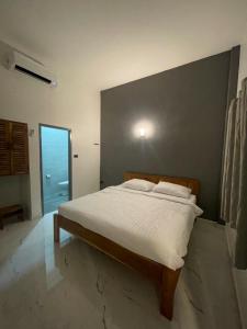 a bedroom with a bed with a white bedspread at NIRAN Hotel & Residence in Ban Talai +11 photos