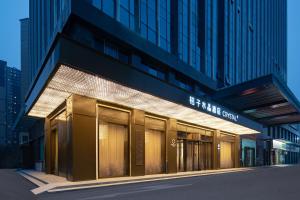 a building with a sign on the front of it at Orange Crystal Hotel Wuhan Jinyinhu in Dongxihu