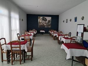 Ein Raum voller Tische und Stühle mit rot-weißen Tischdecken in der Unterkunft Hôtel Ennassim in Sousse + 18 Fotos