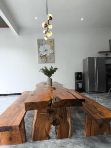 a large wooden table in a living room with at Stella Di Mare Puncak with Private Pool 5 Bedrooms in Sampal 2 +11 photos